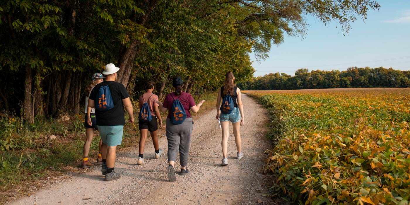 Participants walking along a scenic gravel trail during ARI's Summer Hiking Series at Oxbow Nature Conservancy