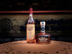 Bottles of Old Forester and Van Winkle Family Reserve Kentucky bourbon displayed on a wooden table at a bourbon education center.